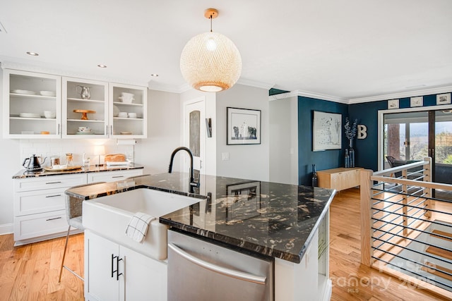 kitchen featuring a sink, stainless steel dishwasher, light wood finished floors, a center island with sink, and pendant lighting