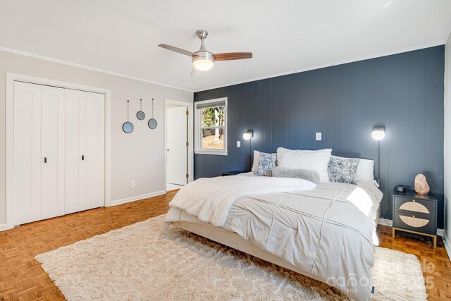 bedroom featuring baseboards, ornamental molding, ceiling fan, and a closet