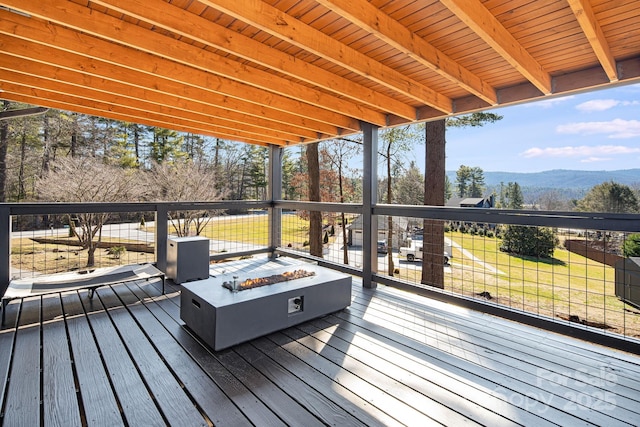 wooden deck featuring a mountain view and a fire pit