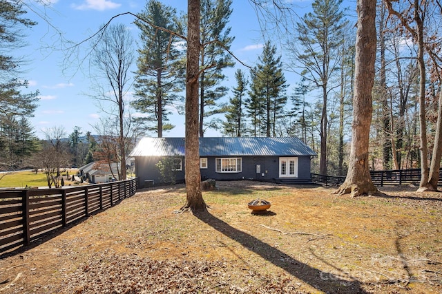 view of front facade with fence, metal roof, and a front yard