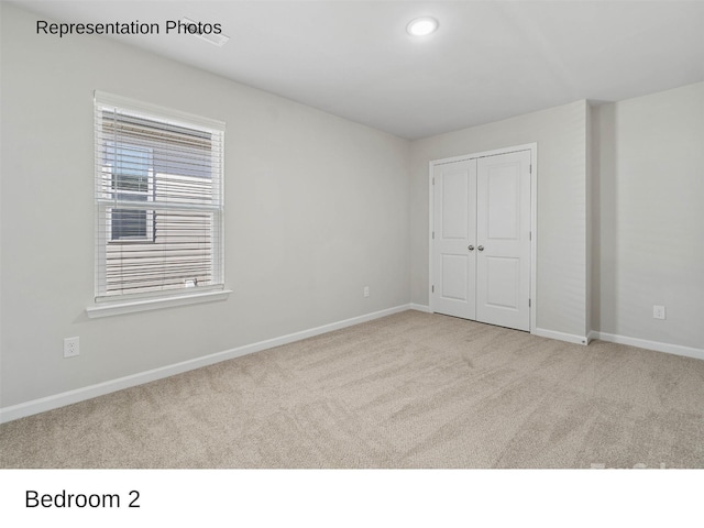 unfurnished bedroom with light carpet and a closet