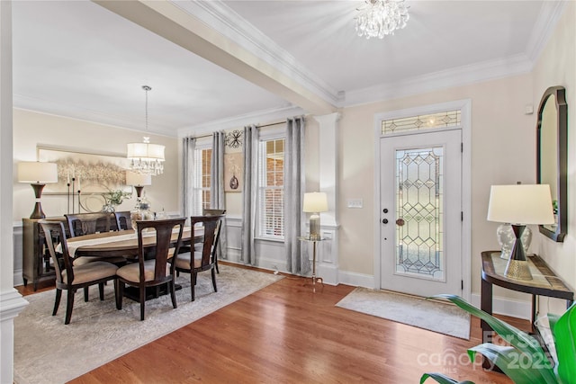 entryway with a chandelier, ornamental molding, and wood finished floors