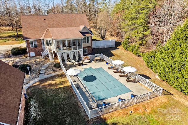 exterior space with a fenced backyard, a sunroom, stairway, a fenced in pool, and a patio area