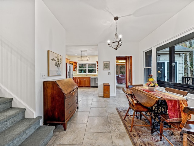 dining area featuring sink and a chandelier