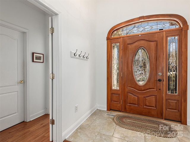 foyer entrance with visible vents and baseboards