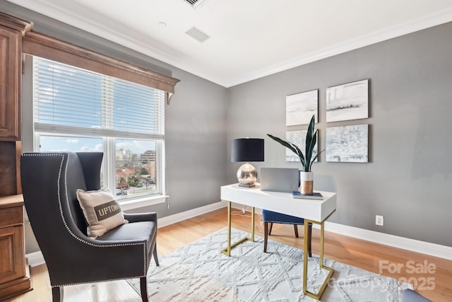 home office featuring ornamental molding and light hardwood / wood-style flooring