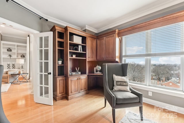 living area featuring ornamental molding, plenty of natural light, and light hardwood / wood-style floors