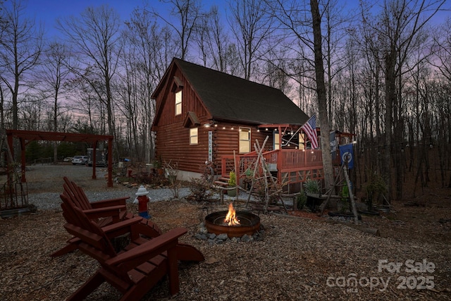 property exterior at dusk with an outdoor fire pit