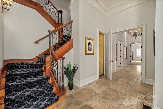 2725 Windsor Rd, Winston Salem, NC 27104 - stairway featuring a chandelier, baseboards, ornamental molding, stone finish floors, and a towering ceiling