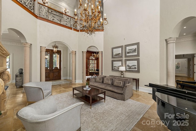 2725 Windsor Rd, Winston Salem, NC 27104 - living room with decorative columns, arched walkways, a high ceiling, baseboards, and a chandelier