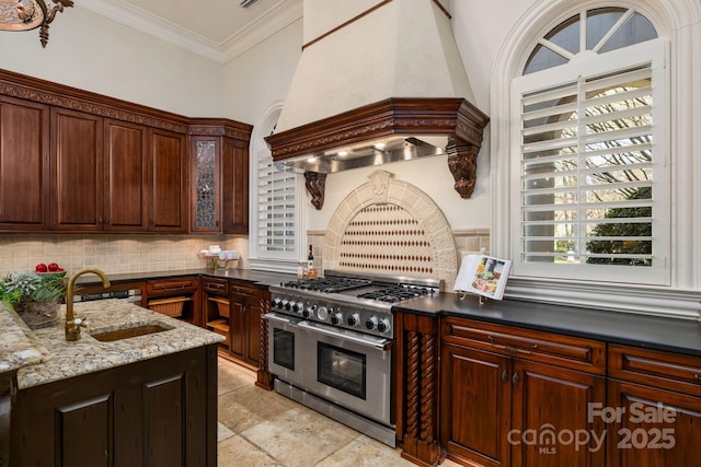 2725 Windsor Rd, Winston Salem, NC 27104 - kitchen with range with two ovens, custom exhaust hood, a sink, decorative backsplash, and glass insert cabinets