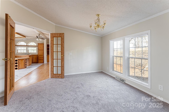 carpeted empty room with an inviting chandelier, crown molding, french doors, and a textured ceiling