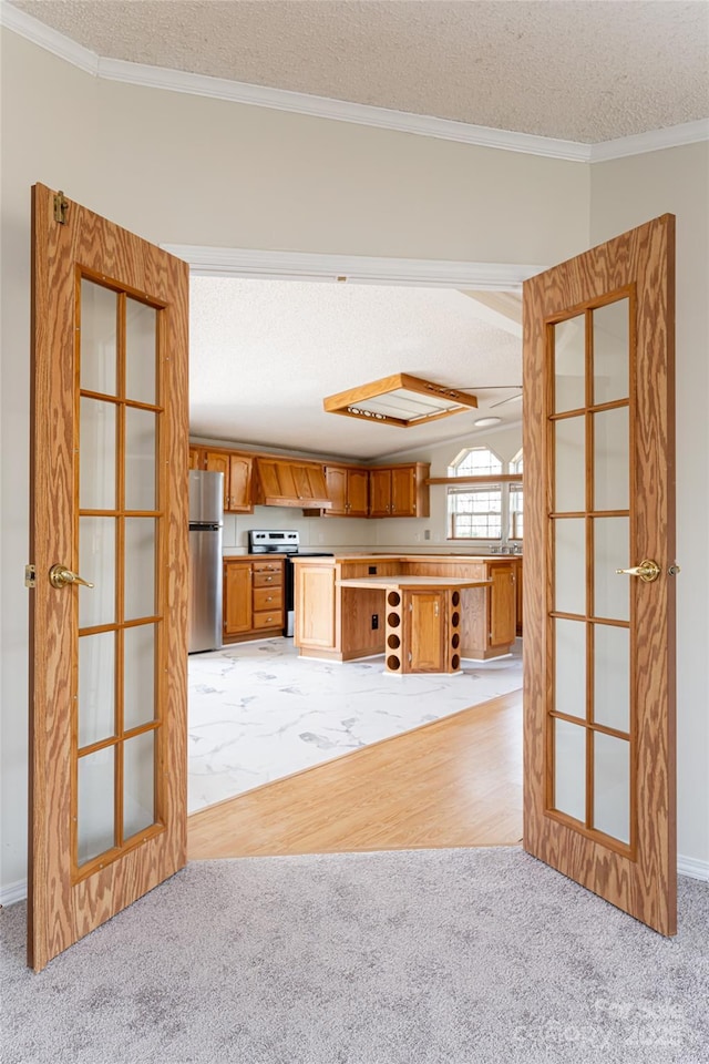 unfurnished living room with crown molding, light carpet, and a textured ceiling