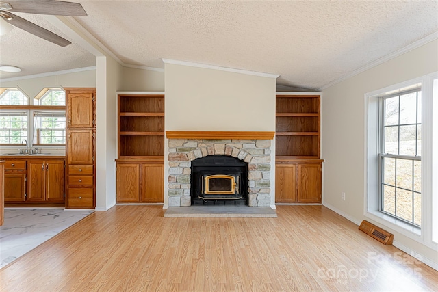 unfurnished living room featuring a wealth of natural light, sink, and light wood-type flooring