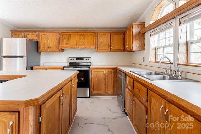 kitchen featuring ornamental molding, appliances with stainless steel finishes, sink, and a textured ceiling