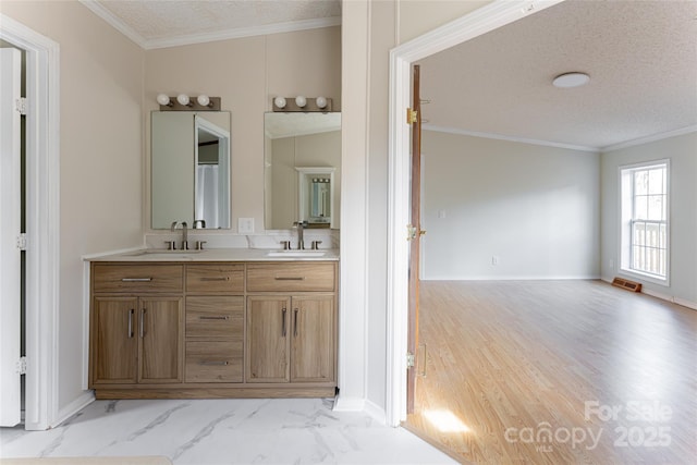 bathroom with hardwood / wood-style flooring, crown molding, vanity, and a textured ceiling