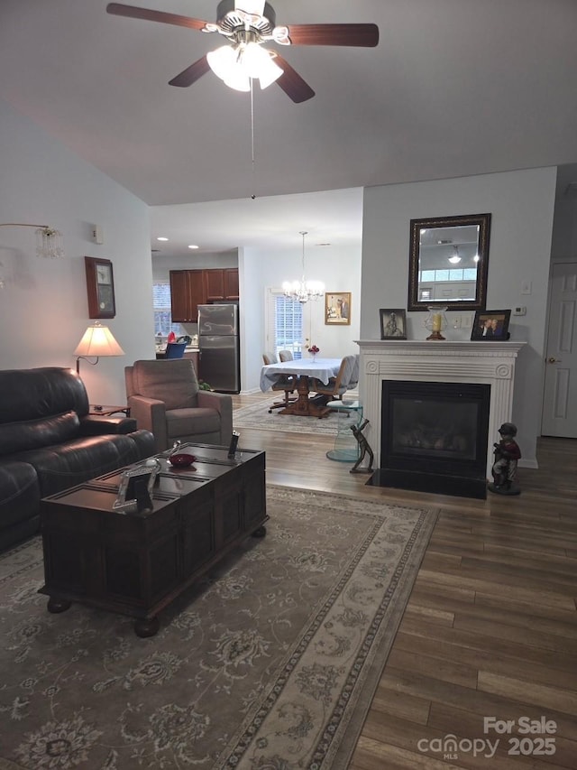 living room with dark hardwood / wood-style flooring and ceiling fan with notable chandelier