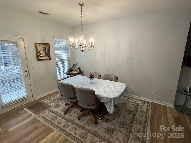 dining area featuring an inviting chandelier and hardwood / wood-style flooring