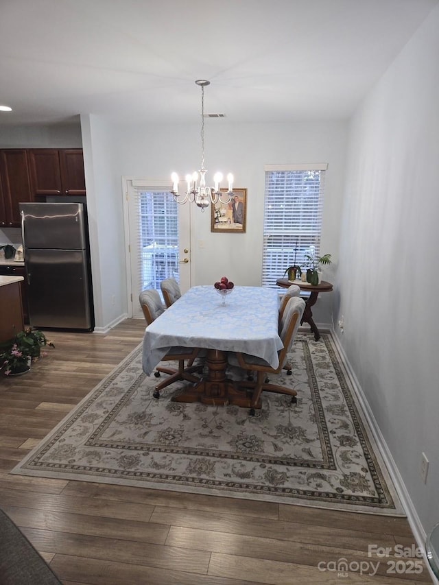 dining space with a chandelier and hardwood / wood-style floors