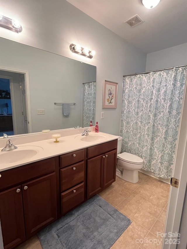 bathroom featuring tile patterned floors, vanity, and toilet