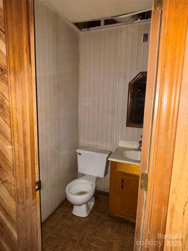 bathroom featuring vanity, parquet floors, and toilet