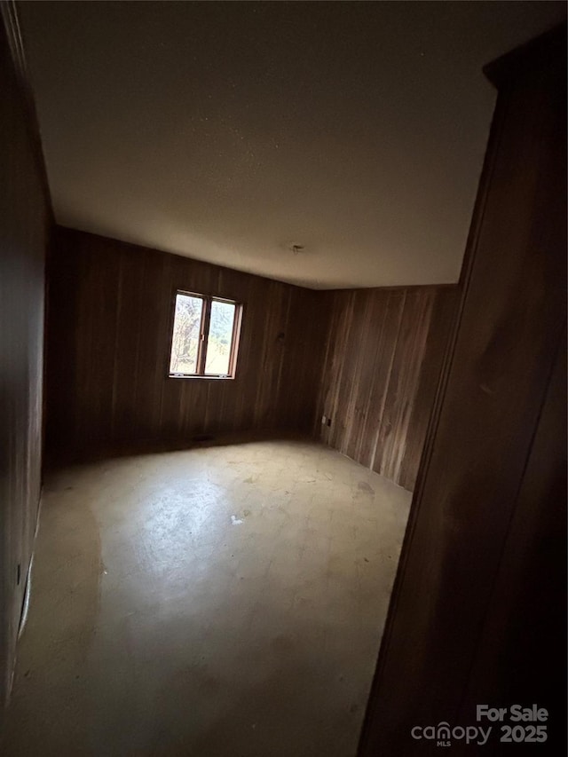 unfurnished room with wood walls