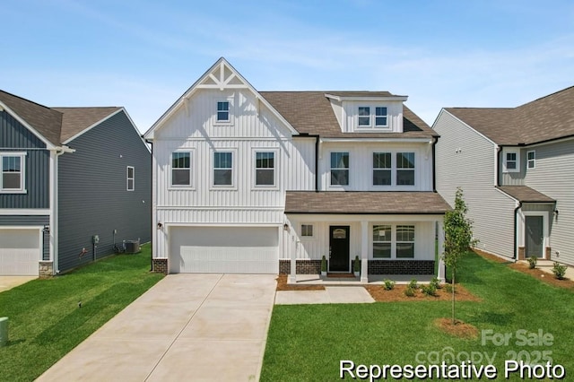 view of front of property with a garage, central AC, and a front lawn