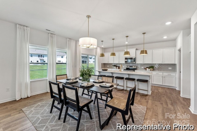 dining space featuring sink and light hardwood / wood-style floors