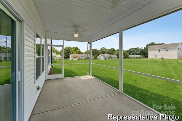 unfurnished sunroom with ceiling fan