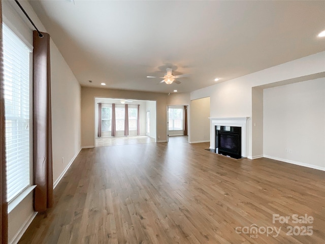 unfurnished living room with wood-type flooring and ceiling fan