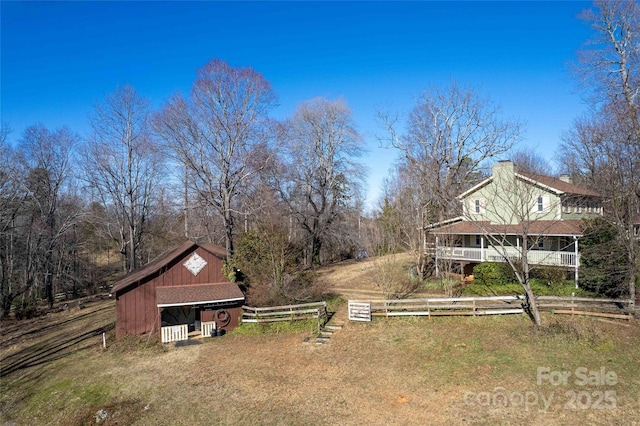 view of yard featuring fence and an outbuilding