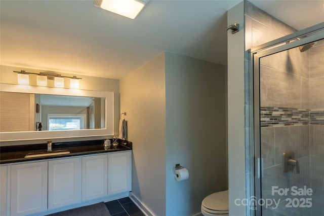 full bathroom featuring toilet, a stall shower, vanity, and baseboards