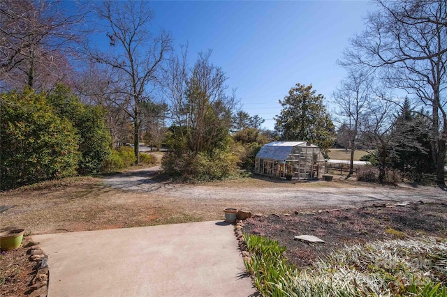 view of yard featuring an outbuilding, driveway, and an exterior structure