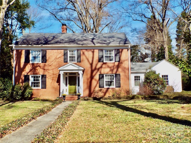 colonial-style house featuring a front lawn