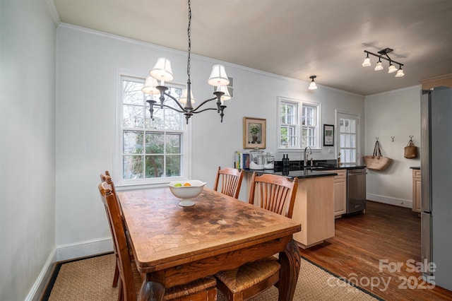 dining space featuring a wealth of natural light, crown molding, dark hardwood / wood-style flooring, and sink