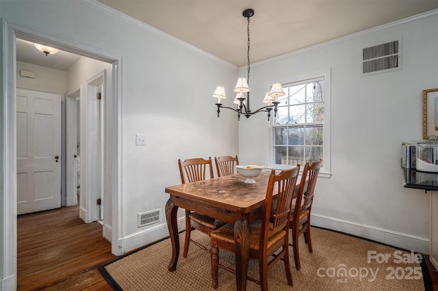 dining room with ornamental molding, dark wood-type flooring, and an inviting chandelier