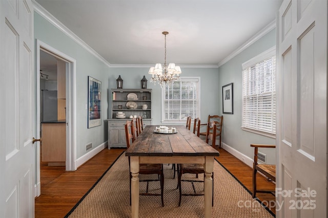 dining space with ornamental molding, a chandelier, and wood-type flooring