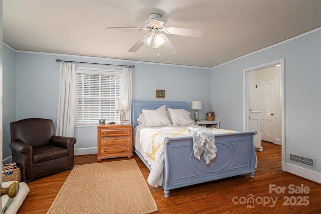 bedroom featuring dark wood-type flooring, crown molding, and ceiling fan