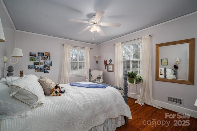 bedroom featuring dark hardwood / wood-style flooring, ornamental molding, and multiple windows
