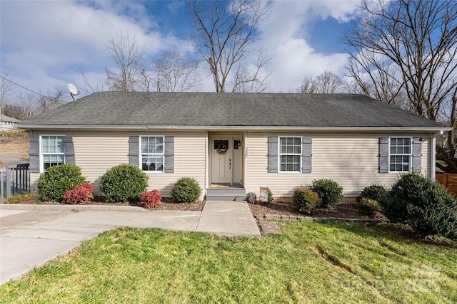 ranch-style home with roof with shingles and a front yard