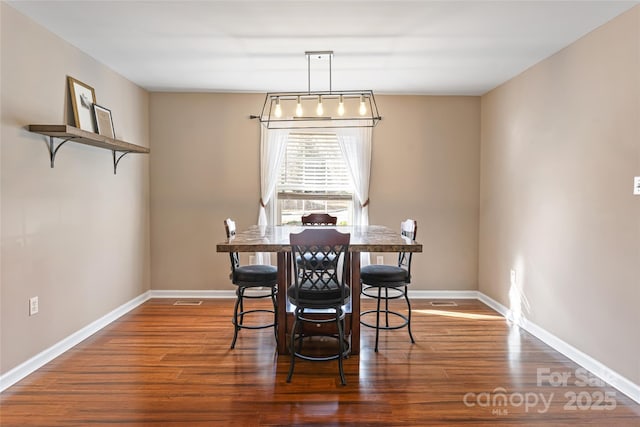 dining room featuring visible vents, dark wood finished floors, and baseboards