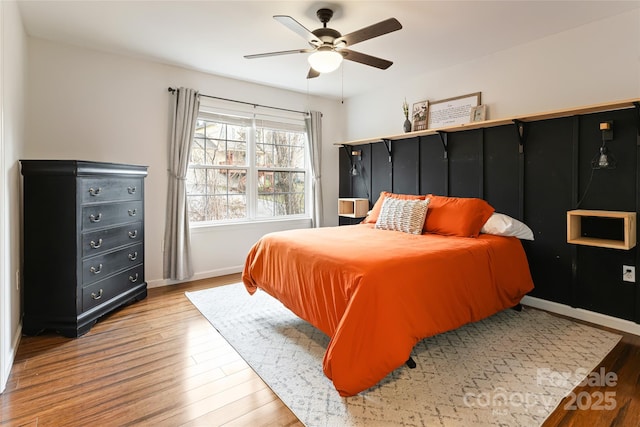 bedroom with baseboards, ceiling fan, and light wood-style floors