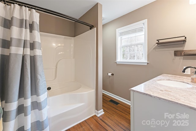 bathroom with shower / bath combo, baseboards, visible vents, wood finished floors, and vanity