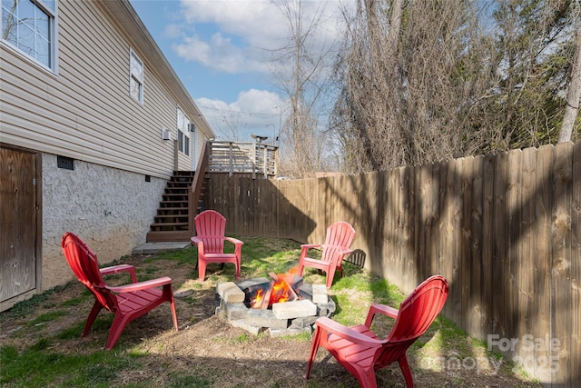 view of yard featuring stairs, an outdoor fire pit, and fence