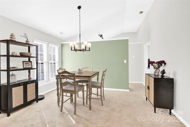 dining room featuring an inviting chandelier, light colored carpet, and lofted ceiling