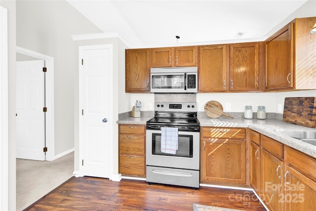 kitchen featuring appliances with stainless steel finishes, dark hardwood / wood-style floors, and light stone countertops