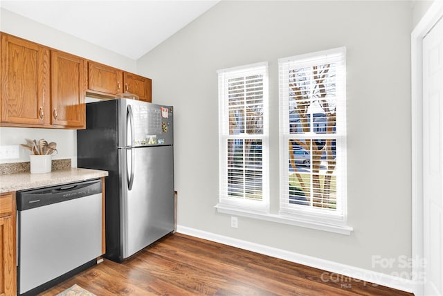 kitchen featuring vaulted ceiling, dark hardwood / wood-style floors, and appliances with stainless steel finishes