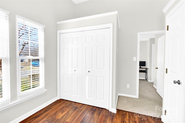 unfurnished bedroom with dark hardwood / wood-style flooring and a closet