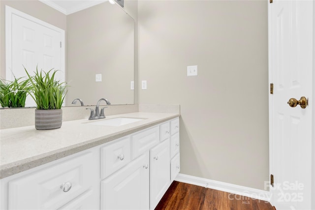 bathroom featuring vanity, ornamental molding, and hardwood / wood-style floors