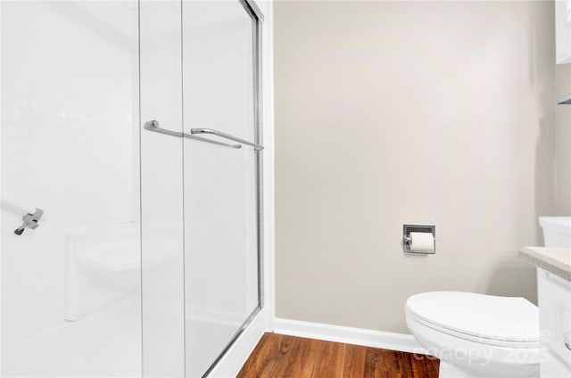 bathroom featuring hardwood / wood-style flooring, toilet, and walk in shower